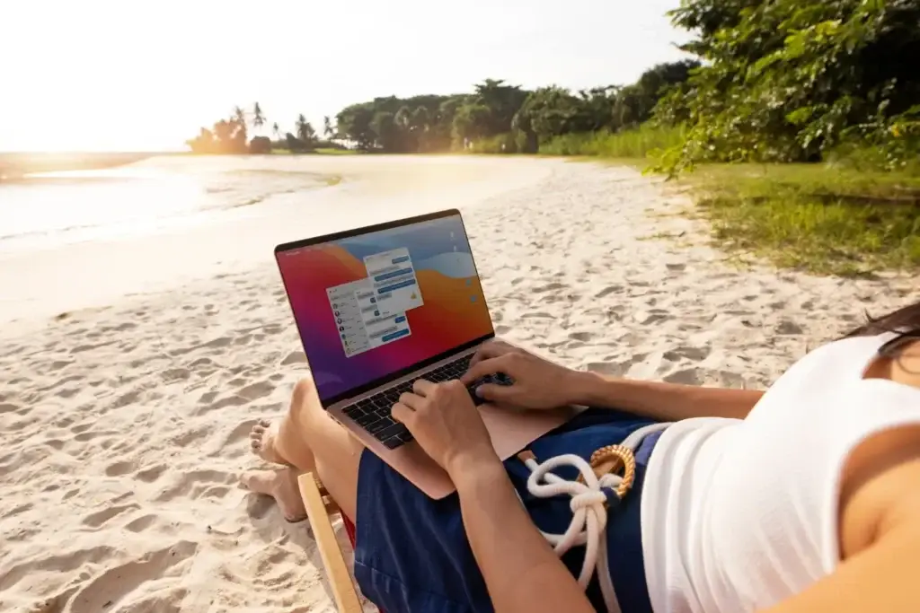 12 consejos útiles para optimizar la durabilidad y mejorar el rendimiento de tu Notebook y MacBook - laptop en la playa - close up-woman working laptop beach